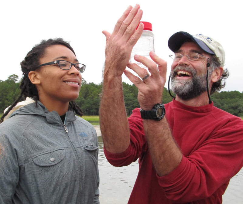 Professor Paul Bartels and student inspect a jar of water
