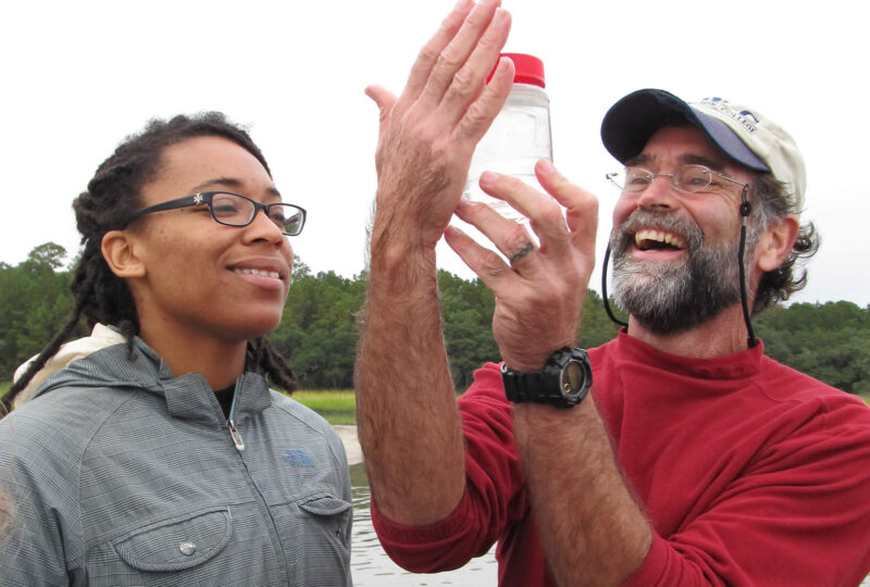 Professor Paul Bartels and student inspect a jar of water