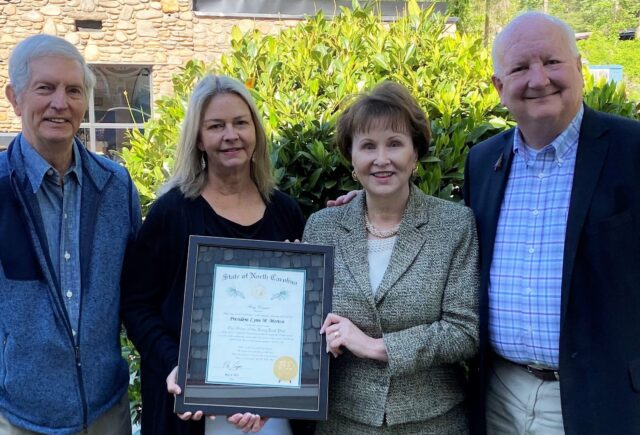 President Lynn Morton stands with Warren Wilson President Emeritus Dr. Doug Orr, North Carolina Independent Colleges and Universities President Dr. Hope Williams, and Warren Wilson Trustee/Interim President Bill Christy, holding up a plaque to receive the Order of the Long Leaf Pine