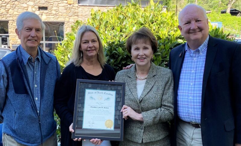 President Lynn Morton stands with Warren Wilson President Emeritus Dr. Doug Orr, North Carolina Independent Colleges and Universities President Dr. Hope Williams, and Warren Wilson Trustee/Interim President Bill Christy, holding up a plaque to receive the Order of the Long Leaf Pine