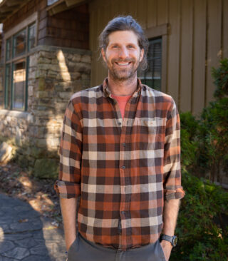 Faculty Member Eric Griffin stands smiling outside of Orr Cottage.
