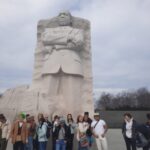 Engage Students in front of a stone statue of Dr. Martin Luther King Jr.