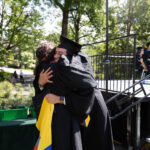 A grad hugs Anna Welton.