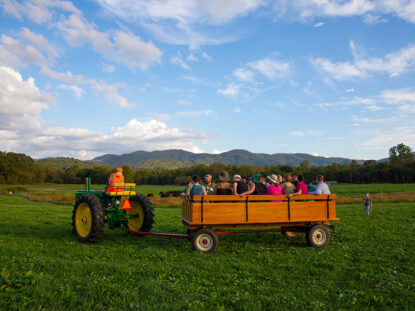 Families enjoy a hayride on the farm for homecoming