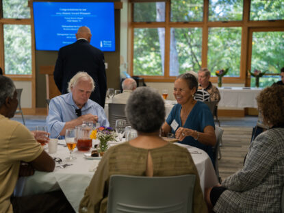 A group of alumni eat and talk with one another at the alumni award ceremony