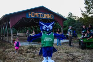 The owl mascot stands in front of the homecoming barn