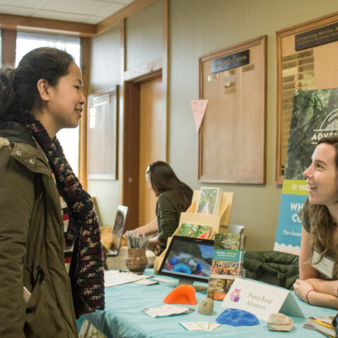 A student tabling talks with an interested student
