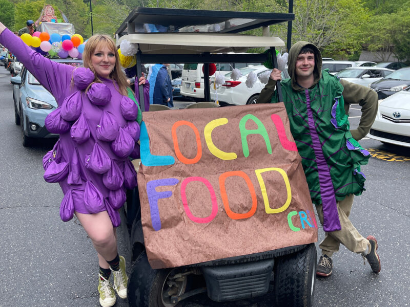 Local foods crew students pose in their fruit costumes beside their decorated golfcart for the Big Gay Earth Day Parade