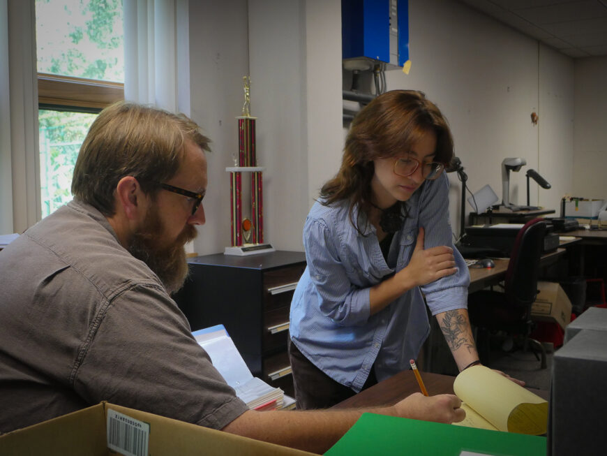 Dr. Jeff Keith works with a library archives student.